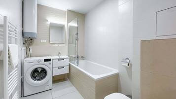 Un baño moderno con lavadora, bañera y retrete.
