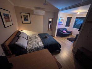 A bedroom with a bed, a desk, a chair, and a sofa. - Ironbark cabin, a tranquil secluded getaway between Daylesford and Kyneton. (Drummond)