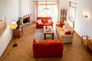 A living room with a fireplace, a sofa, a coffee table, and a television.