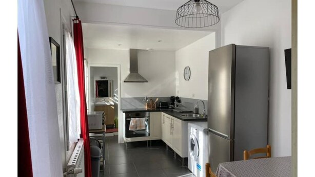 Eine moderne Küche mit Kühlschrank, Backofen und Waschmaschine.