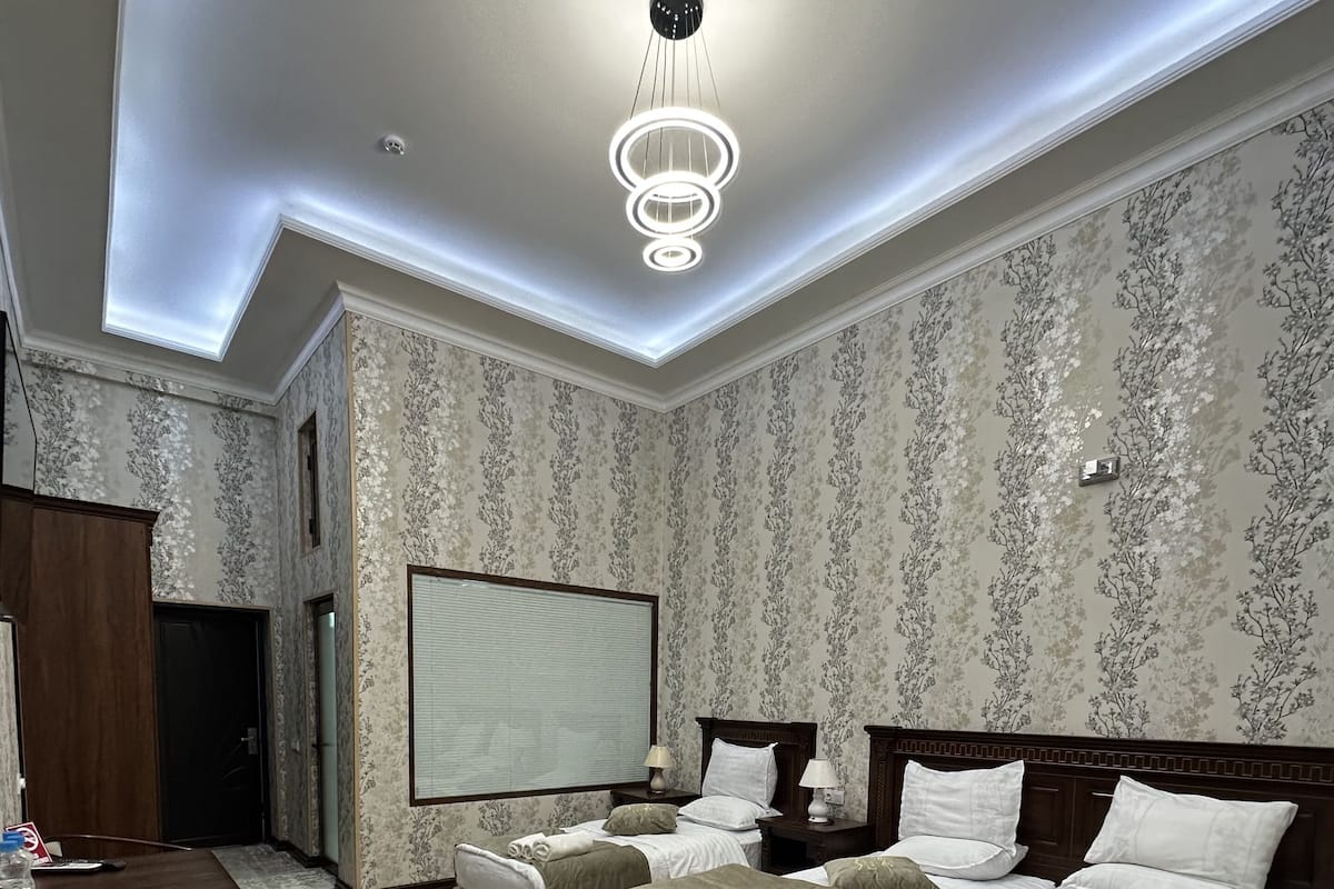 A hotel room with a large bed, a desk, and a large window.