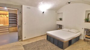 Een slaapkamer met een bed, een kledingkast en een klein bureau.