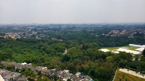 Un quartier résidentiel avec des maisons, de la verdure et une vue lointaine sur la ville.