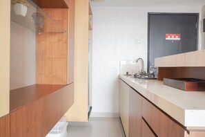 Kitchen area with a sink, coffee maker, and kettle, adjacent to a door.