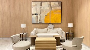 A modern living room with a beige sofa, two side tables with lamps, and a coffee table. - Simply Look And Comfy Studio At Tokyo Riverside Pik 2 Apartment (Teluknaga)