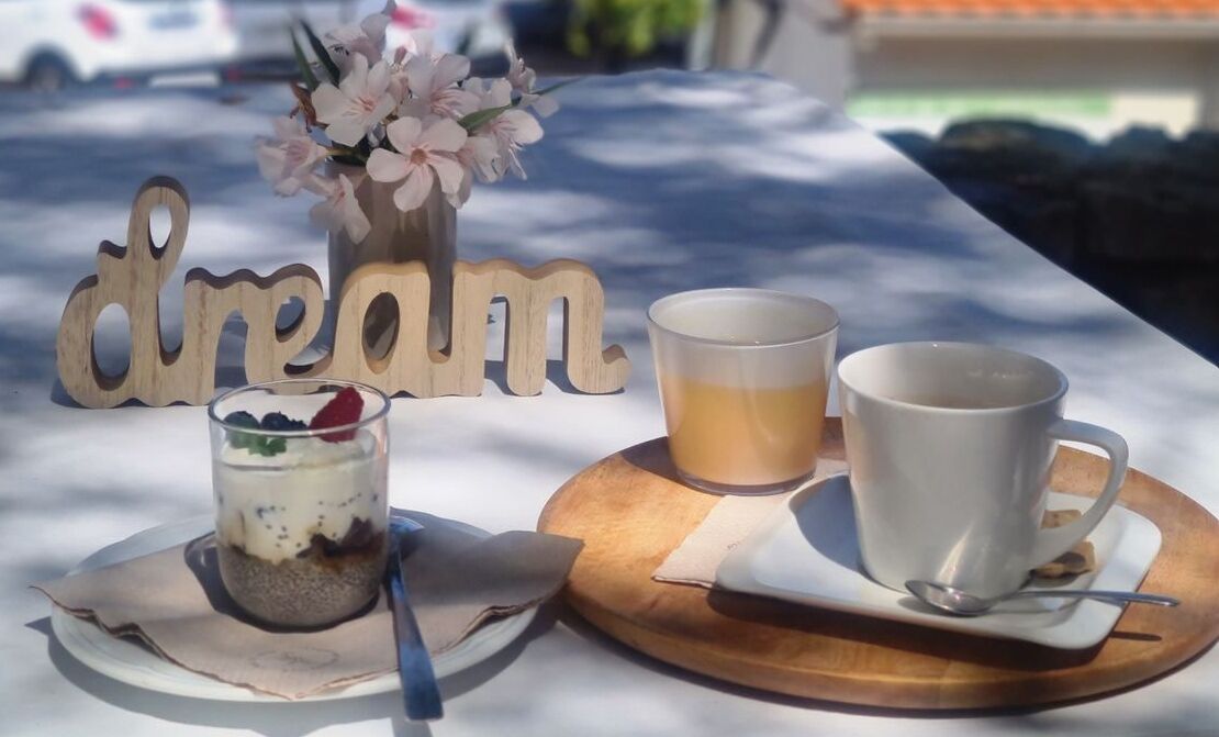 Une table avec un dessert, une tasse de thé et une tasse sur un plateau en bois.
