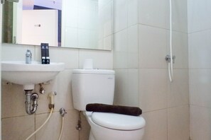 Bathroom features a sink, toilet, and shower area with a showerhead and control panel.