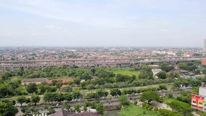 A cityscape with a prominent elevated highway, green spaces, and residential areas. - Cozy Studio at Lagoon Bekasi Town Square Apartment (Bekasi)