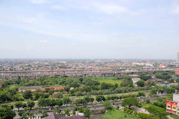 A cityscape with a prominent elevated highway, green spaces, and residential areas. - Cozy Studio at Lagoon Bekasi Town Square Apartment (Bekasi)