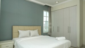 A bedroom with a bed, nightstand, wardrobe, and a window with curtains. - Comfy 1Br At Bellezza Apartment (Jakarta)
