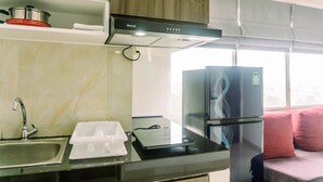 A compact kitchen with a sink, countertop, and a built-in oven. - Minimalist 2Br Apartment At Serpong Garden Near Train Station (Cisauk)