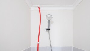 A shower with a red hose and a chrome showerhead in a white-walled bathroom. - Best Deal And Comfy Studio At Puncak Kertajaya Apartment (Surabaya)
