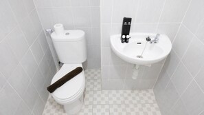 A bathroom with a white toilet, a sink, and a towel rack. - Modern And Homey 2Br At Puncak Kertajaya Apartment (Surabaya)