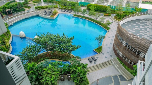 Une grande piscine circulaire, entourée d’une végétation luxuriante et bordée d’une architecture moderne.