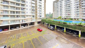 Un edificio residencial de varios pisos con balcones, estacionamiento y piscina.