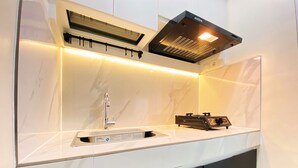 Una cocina moderna con estufa integrada, un lavamanos y una campana extractora.