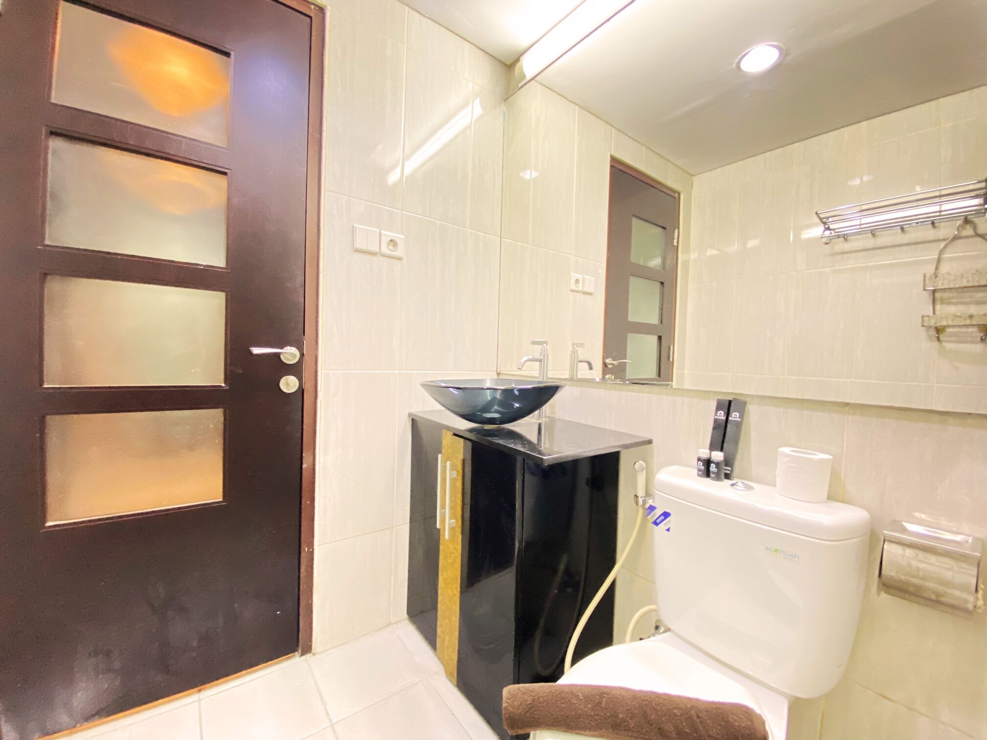 Une salle de bain équipée de toilettes, d’un bidet, d’un lavabo et d’un miroir.