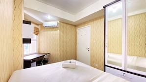 A hotel room with a bed, a desk, and a wardrobe. - Cozy Living 1Br Apartment At Parahyangan Residence (Bandung)