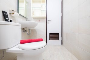 Une salle de bain avec des toilettes, un lavabo et un miroir.