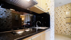 Eine moderne Küche mit einer Granit Arbeitsplatte, Edelstahlgeräten und einer Stein Rückwand.