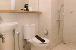 Un baño con inodoro, lavamanos y ducha.