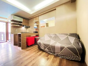 A compact living space with a kitchenette, a sofa, and a dining area.