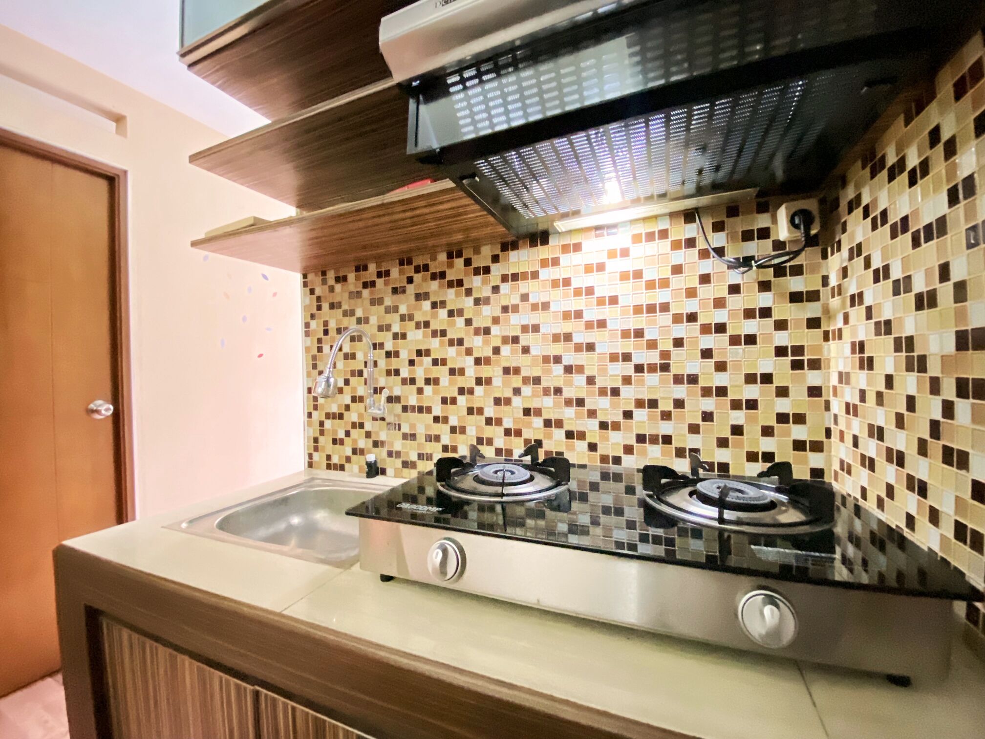 A kitchen with a gas stove, a sink, and a tiled backsplash.