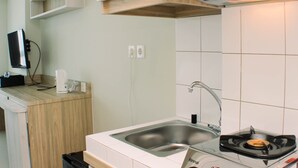 Eine moderne Küche mit einer Edelstahlspüle, einem eingebauten Herd und Holzschränken.