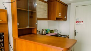 A kitchen with wooden cabinets, a countertop, a sink, and a door with a fire safety sign.