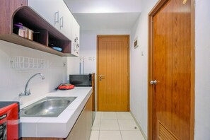 Studio | Private kitchen | Fridge, stovetop, cookware/dishes/utensils - Classic And Cozy Studio At Cinere Bellevue Suites Apartment (Depok)