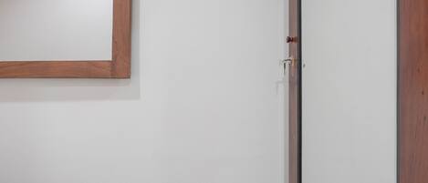 A white door with a wooden frame and a small window.