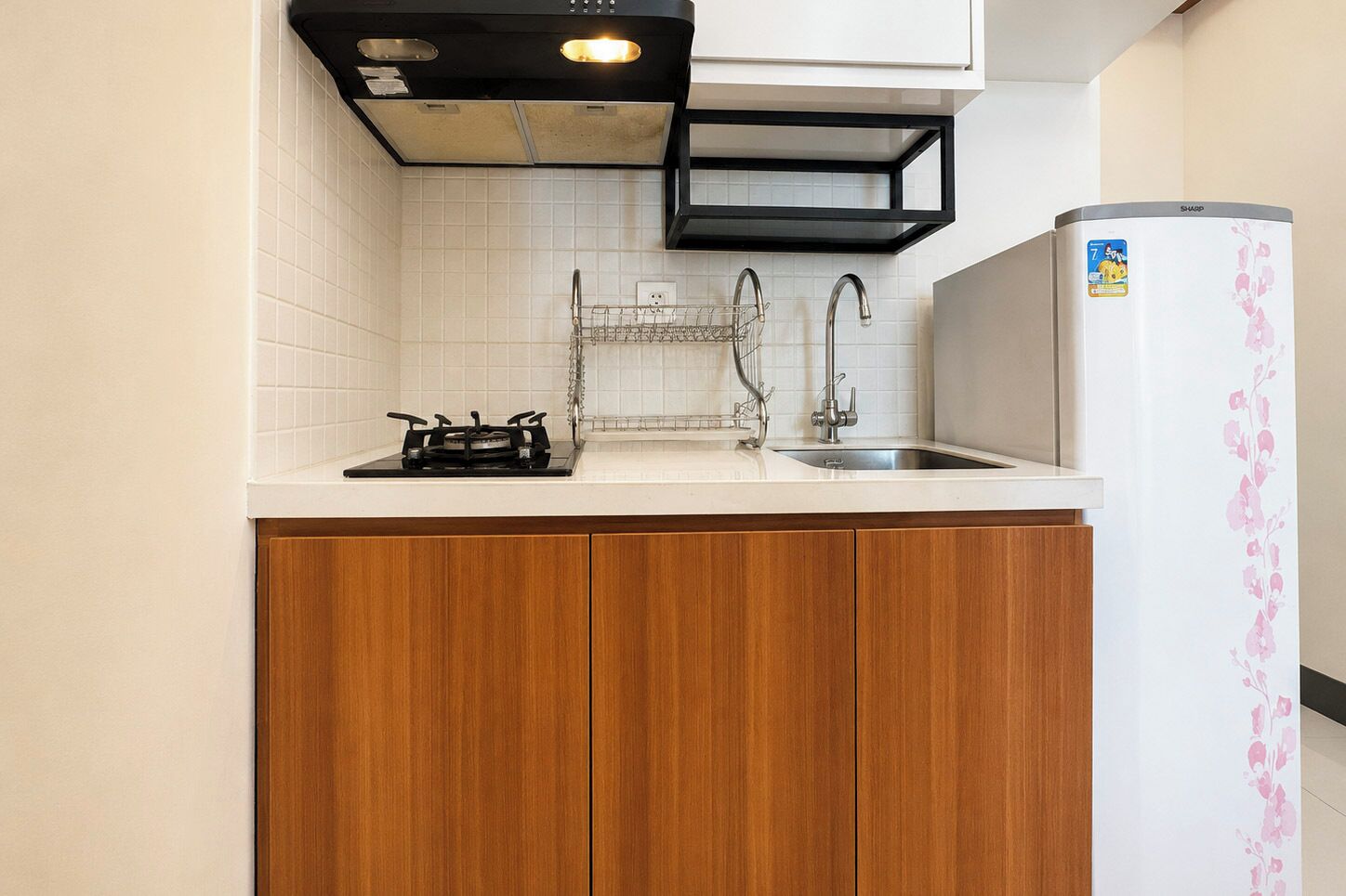 A compact kitchen with a gas stove, a sink, and a refrigerator.