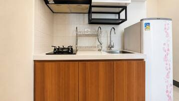 A compact kitchen with a gas stove, a sink, and a refrigerator.
