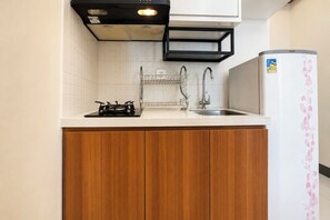 Una cocina compacta con estufa a gas, un fregadero y un refrigerador.