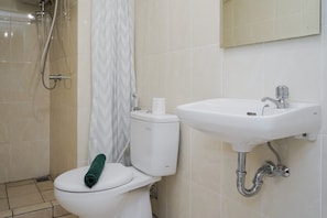 A bathroom with a toilet, a sink, and a shower.