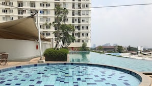 Une piscine dont la profondeur est indiquée à 60 cm, entourée d’une terrasse carrelée.