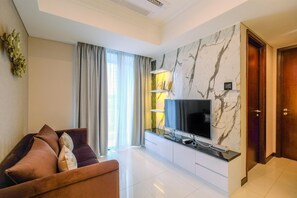 A modern living room with a flat-screen TV, a sofa, and a marble wall.