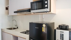 A compact kitchen with a microwave, refrigerator, and water dispenser. - Minimalist And Comfortable Studio Apartment Tokyo Riverside Pik 2 (Teluknaga)