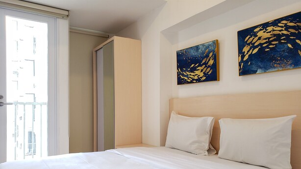 A hotel room with a bed, two pillows, and two paintings on the wall. - Minimalist And Comfortable Studio Apartment Tokyo Riverside Pik 2 (Teluknaga)