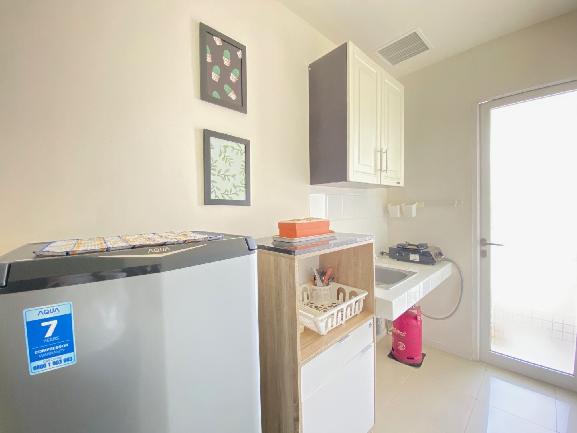 A compact kitchen with a refrigerator, a sink, and a small countertop.