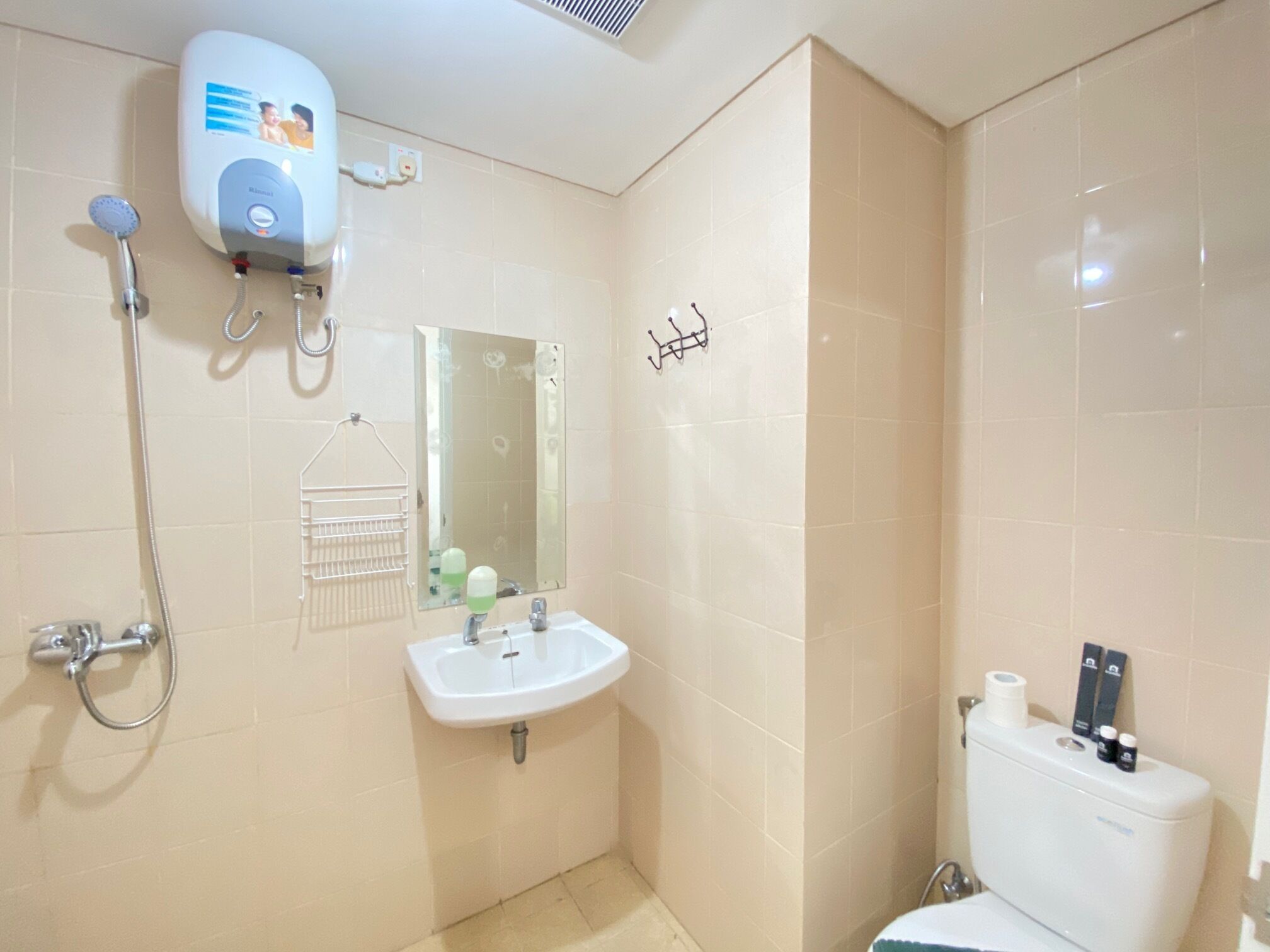 A bathroom with a shower, sink, mirror, and toilet.