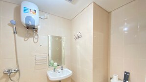 Un baño con ducha, lavabo, espejo e inodoro.