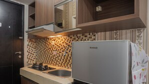 A kitchen with a built-in stove, a sink, and a refrigerator. - Cozy Living Studio Apartment At Belmont Residence Near Puri (Jakarta)
