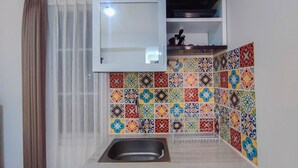 Una cocina con un lavabo, un armario y salpicadero de azulejos.