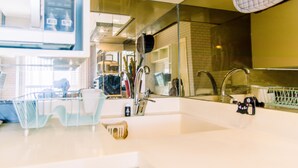 A modern kitchen with a large sink, stainless steel appliances, and a glass backsplash. - Warm And Comfort Stay 1Br Apartment At Silkwood Residences (Tangerang)