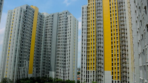 A high-rise residential building with multiple balconies and a swimming pool area. - Fully Furnished Studio At Springlake Summarecon Apartment (Bekasi)