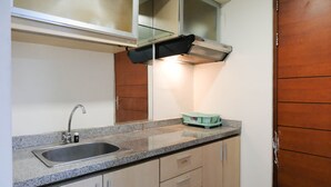 Eine Küche mit Granit Arbeitsplatte, Edelstahl-Spüle und beige farbenen Schränken.