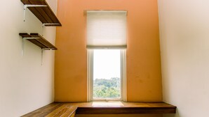 A corner room with a window, wooden bench, and metal shelves. - Cozy Stay Studio Apartment At Easton Park (South Tangerang)