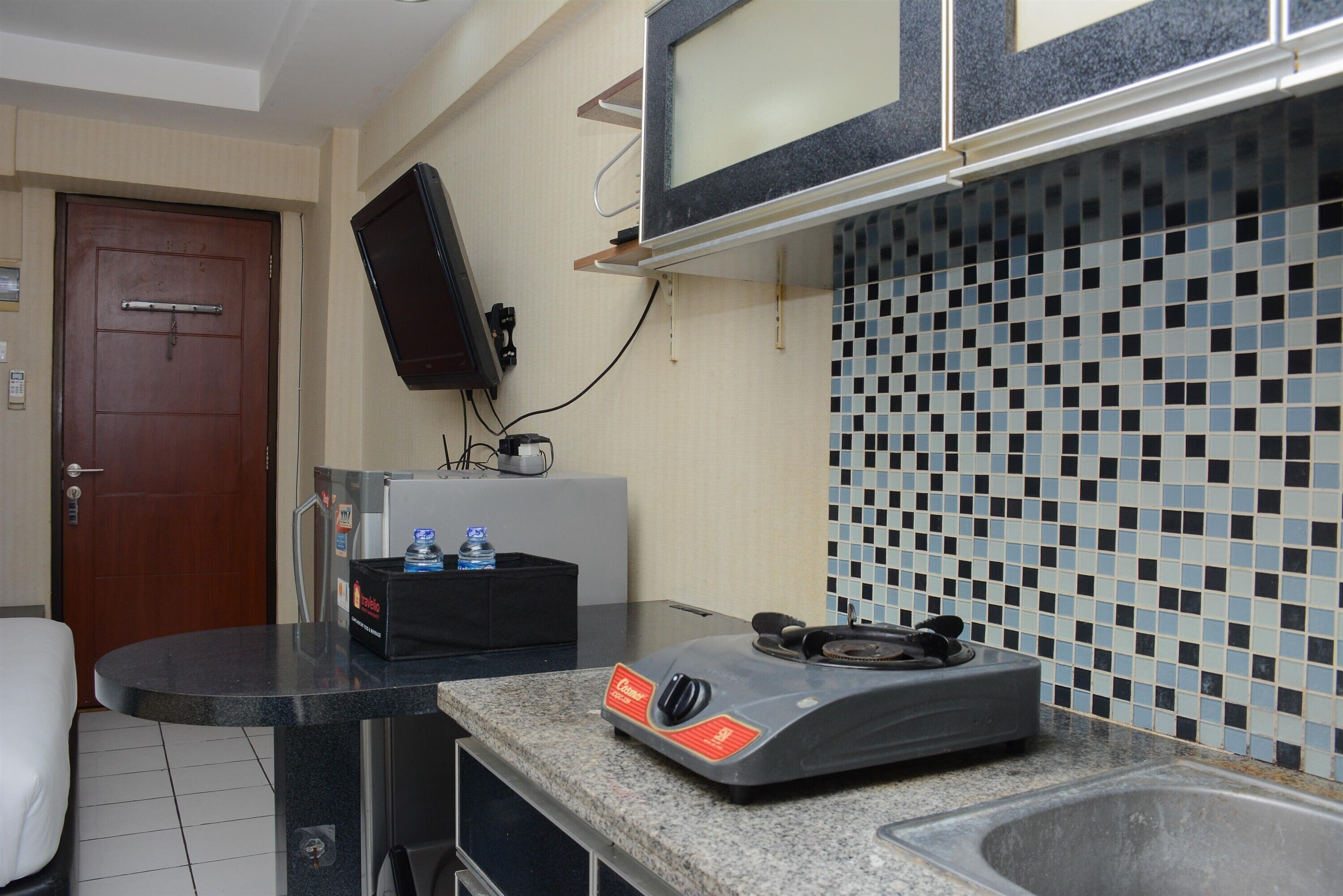 A kitchen with a microwave, a gas stove, and a tiled backsplash.