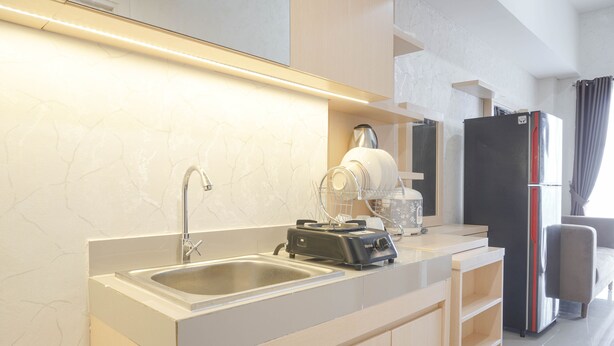 A modern kitchen with a double sink, a coffee maker, and a refrigerator. - Comfort And Warm 2Br At Parkland Avenue Apartment (South Tangerang)